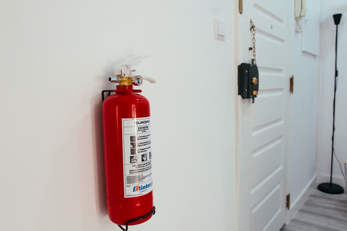 Un extincteur rouge fixé au mur