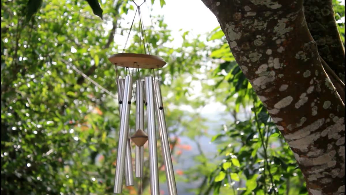 Wind chime and reflective objects moving in a garden