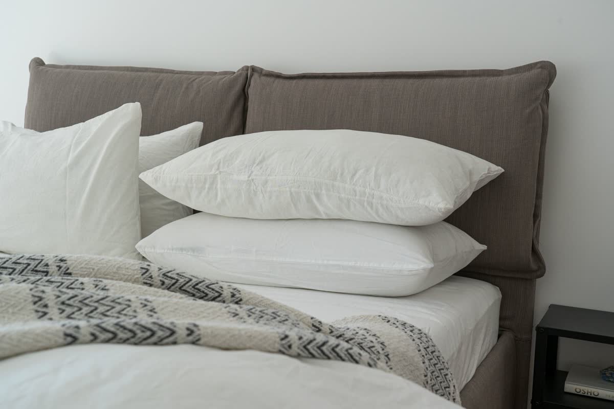 Una cama hecha con almohadas y ropa de cama suave
