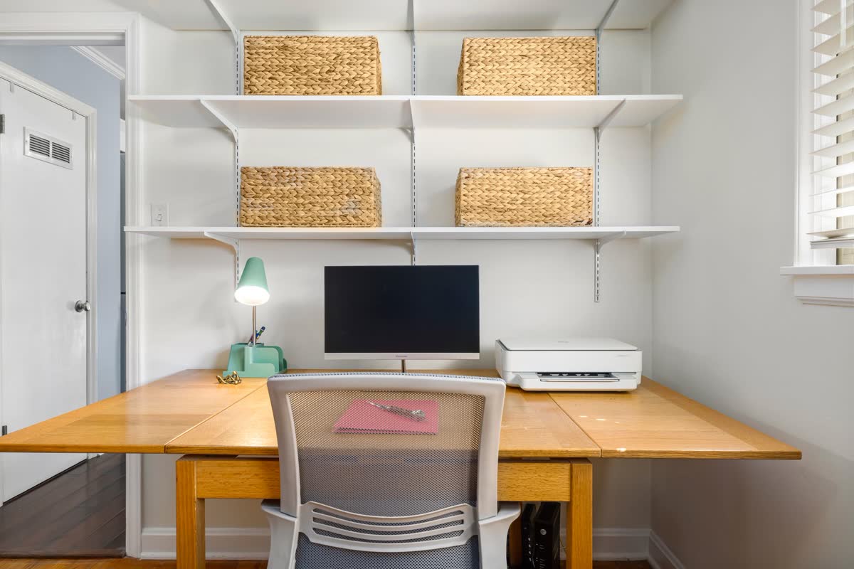 A bright, organized dorm desk with shelves and baskets