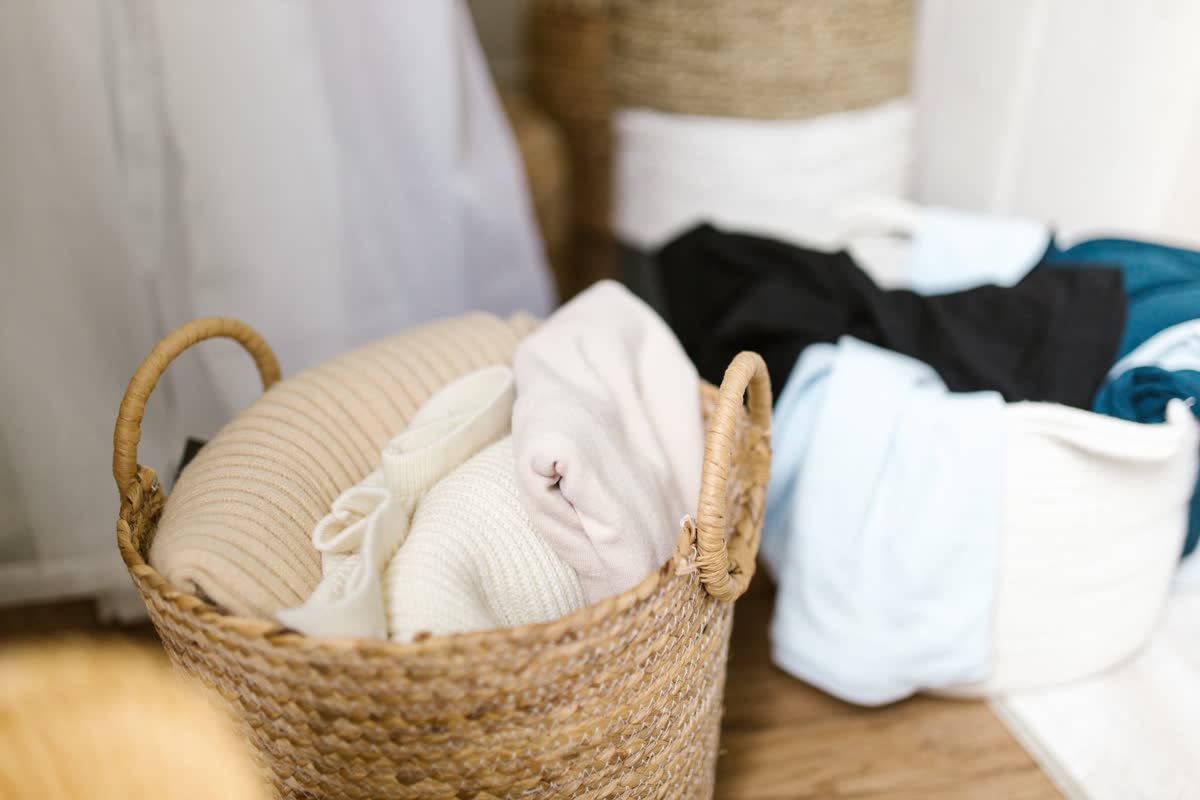 Un cesto de ropa tejido con ropa doblada