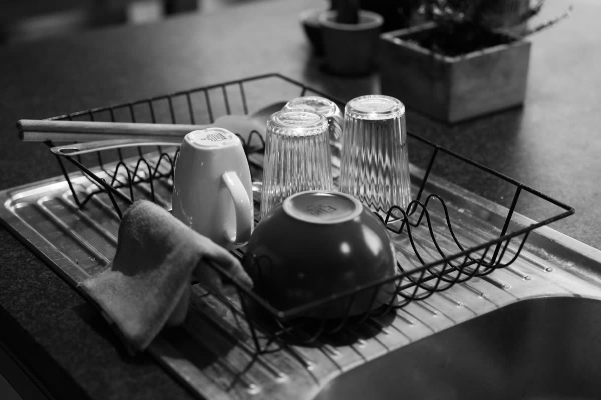 Des tasses et des verres qui sèchent sur un petit égouttoir