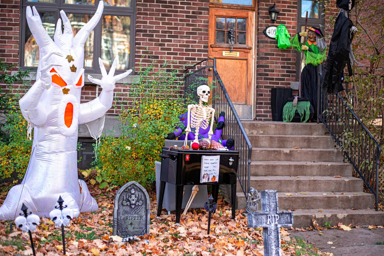Um fantasma inflável e um esqueleto num jardim decorado