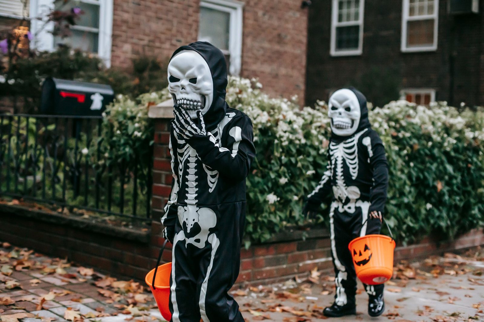 Costumed kids walking along a suburban sidewalk near the street
