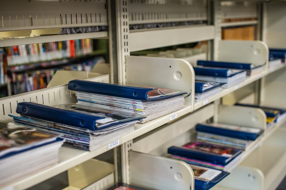 Une étagère avec des chemises et des livres