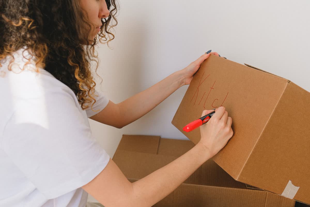 Etiquetando una caja de mudanza con un marcador