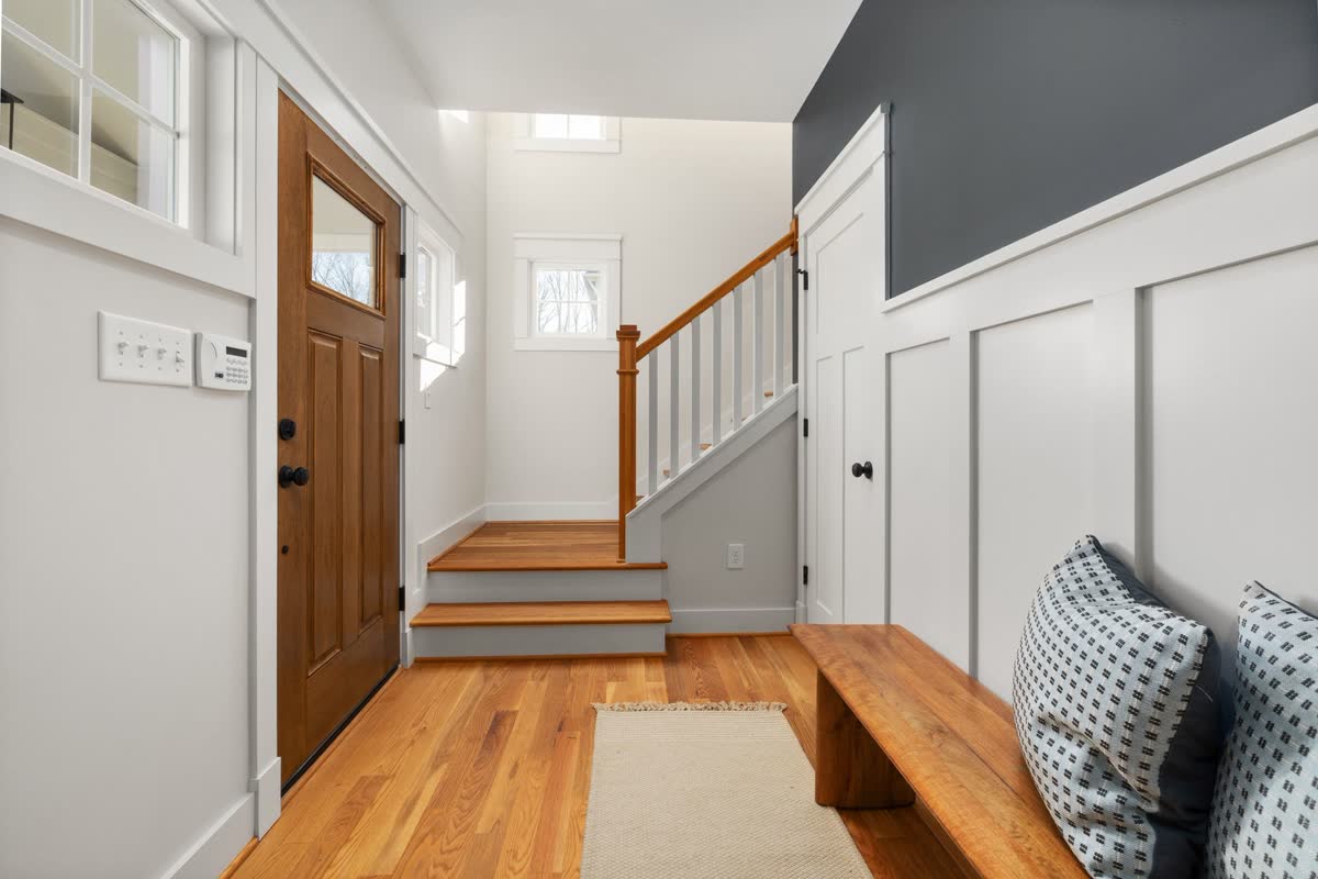A bright entryway with a bench and hooks