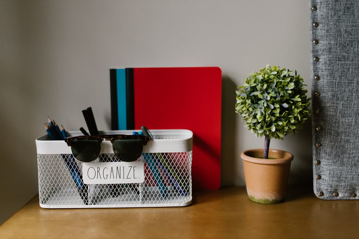 A desk organizer caddy holding supplies with notebooks